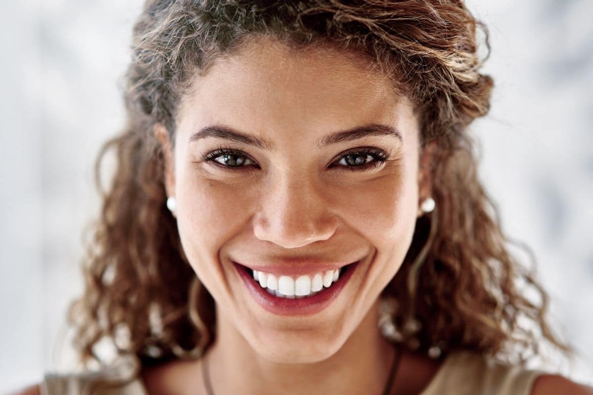Woman smiling showing results of cosmetic dental treatments in Wellington, FL.