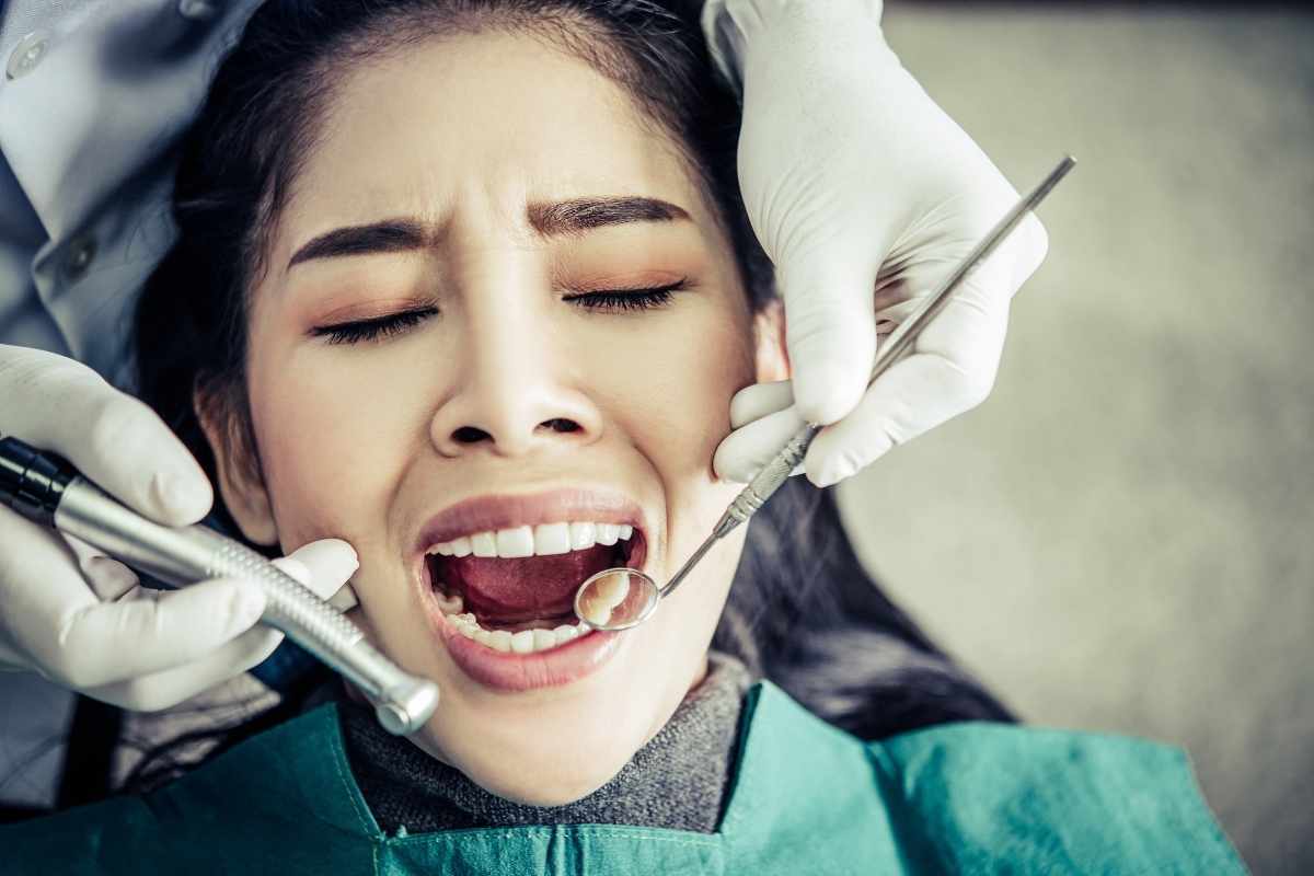 Dentist examining patient's teeth during cavity treatment in Wellington, FL.