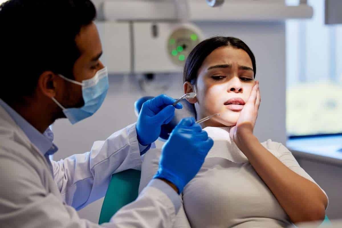 Dentist examining patient's teeth during dental procedure in modern dental office.